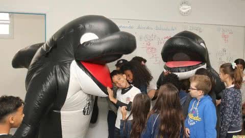 Alunos se empolgam com visita das mascotes do Santos FC - Imagem: reprodução Prefeitura de Santos